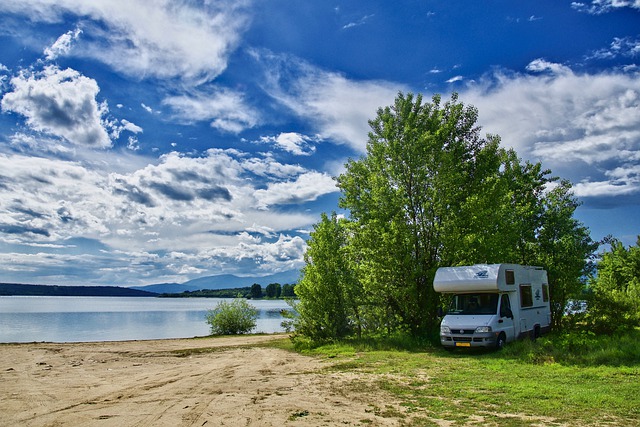 camper set up beside lake and trees