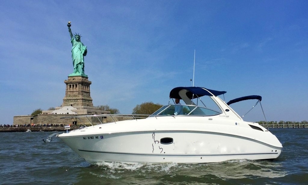 Sea Ray Sundancer boat cruising in front of the statue of liberty